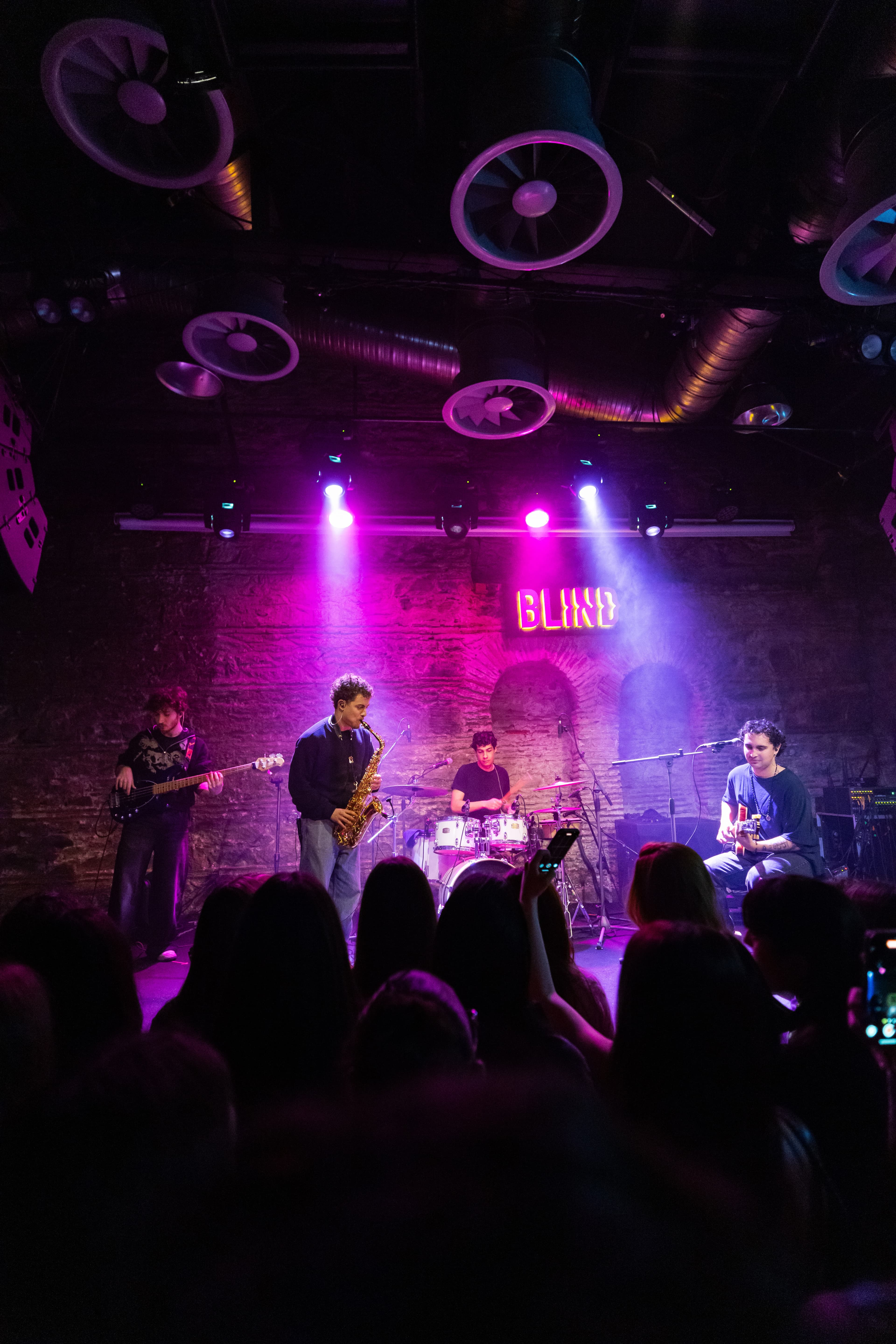 Maymun Collective performing live on stage under pink and purple lights at Blind.