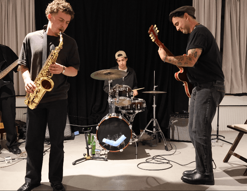 Saxophone, drums, and guitar during a Maymun Collective rehearsal in the studio.