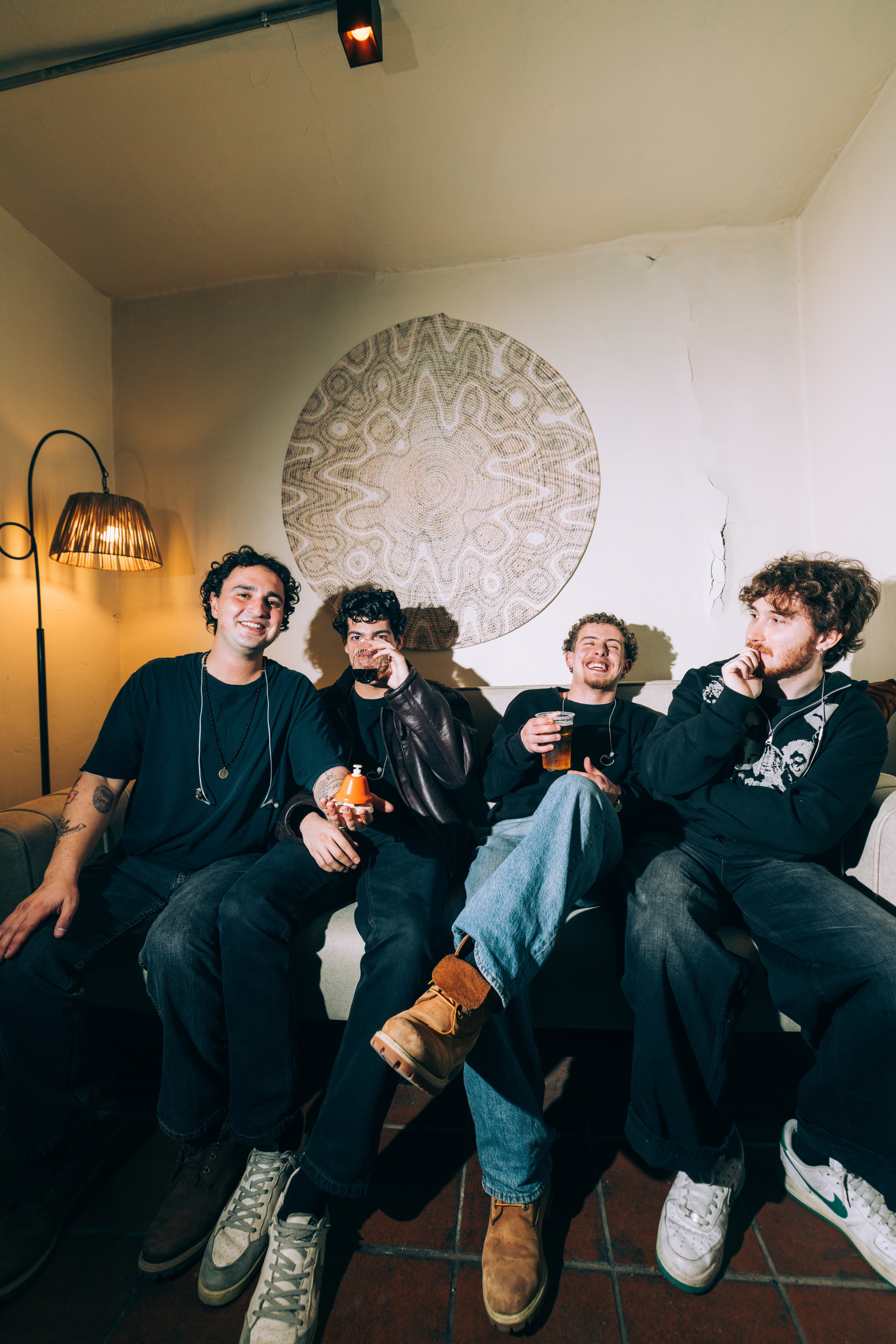 The four members of Maymun Collective relaxing on a couch backstage.
